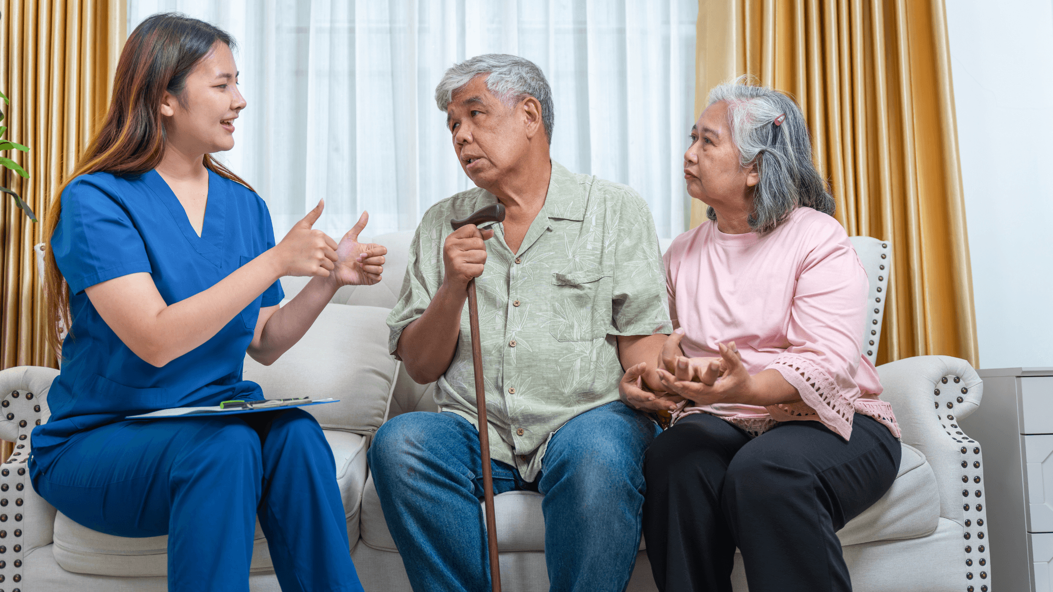 A care coordinator talking with a senior couple at home